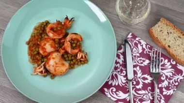 Bir tabak mürekkep balığı, bir bardak şarap ve ekmek ile bezelye.