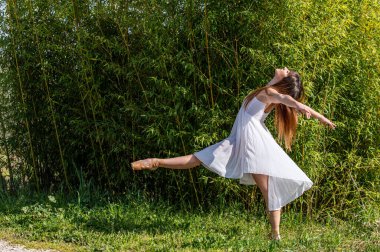 Beyaz elbiseli ve sivri uçlu ayakkabılı çeşitli pozlarda bir balerin.