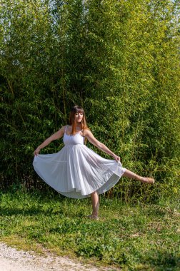 Beyaz elbiseli ve sivri uçlu ayakkabılı çeşitli pozlarda bir balerin.