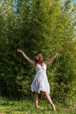 Beyaz elbiseli ve sivri uçlu ayakkabılı çeşitli pozlarda bir balerin.