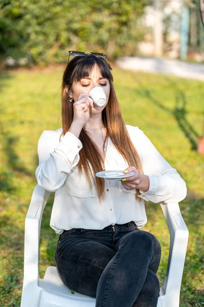 girl drinking coffee in the garden in the afternoon