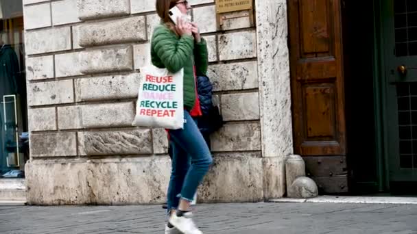 Mujer de la calle pidiendo limosna apoyada en un edificio — Vídeos de Stock