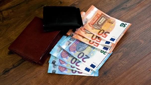 木製のテーブルとユーロ紙幣と異なる財布 — ストック動画