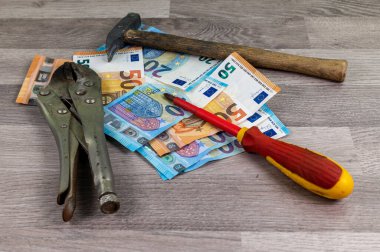 Ahşap arka planda 20 ve 50 avroluk banknot ve çalışma araçları