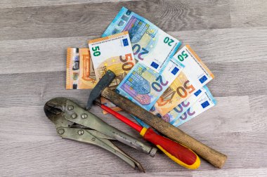 Ahşap arka planda 20 ve 50 avroluk banknot ve çalışma araçları