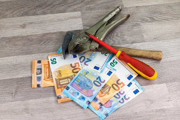 Ahşap arka planda 20 ve 50 avroluk banknot ve çalışma araçları