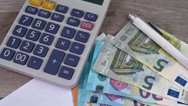 W biurze banknoty euro z kalkulatorem, wykresami i przedmiotami — Wideo stockowe