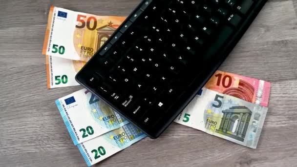 Computertastatur mit Euro-Banknoten verschiedener Stückelungen — Stockvideo