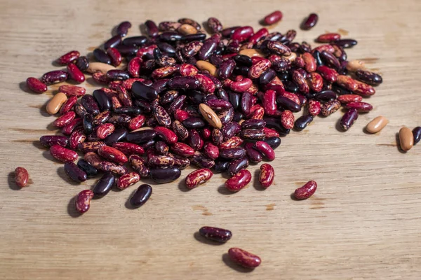 Red, black and white beans close-up on a white oak kitchen board. Vegetarian menu element.