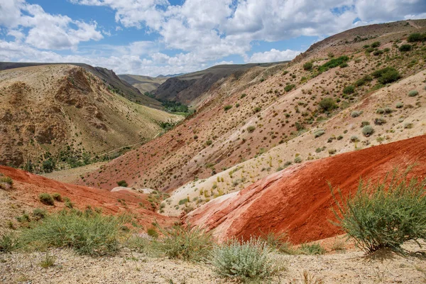 Martian landscape in the mountains of the Altai Republic in Russia. The landscape is made of red and orange rocks. Travel photo from a summer trip.