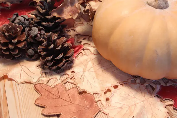 Table d'automne, citrouille et cônes sur une surface en bois — Photo