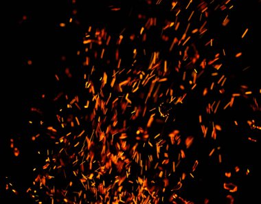 Siyah arkaplanda kıvılcımlar saçan bir ateş alevi