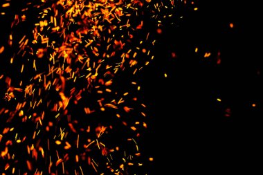 Siyah arkaplanda kıvılcımlar saçan bir ateş alevi