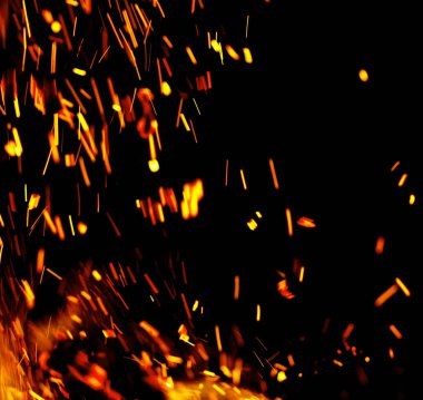 Siyah arkaplanda kıvılcımlar saçan bir ateş alevi