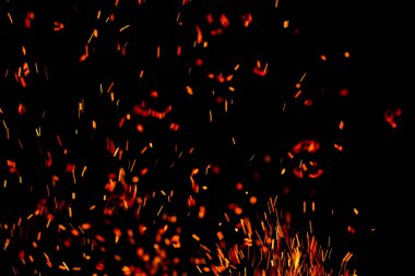 Siyah arkaplanda kıvılcımlar saçan bir ateş alevi