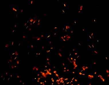 Siyah arkaplanda kıvılcımlar saçan bir ateş alevi