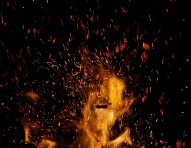 Siyah arkaplanda kıvılcımlar saçan bir ateş alevi