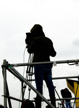 İş yerinde elinde kamera olan bir adamın silueti.