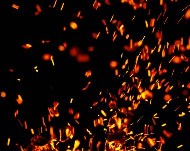 Siyah arkaplanda kıvılcımlar saçan bir ateş alevi