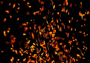 Siyah arkaplanda kıvılcımlar saçan bir ateş alevi