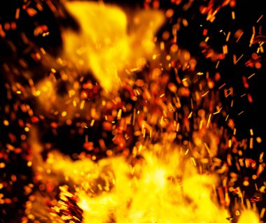 Siyah arkaplanda kıvılcımlar saçan bir ateş alevi