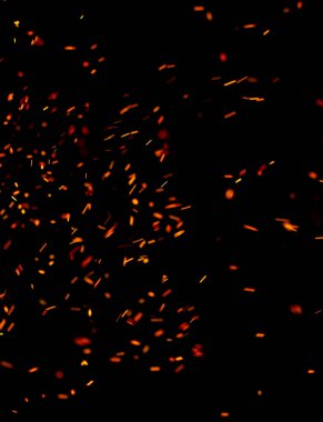 Siyah arkaplanda kıvılcımlar saçan bir ateş alevi