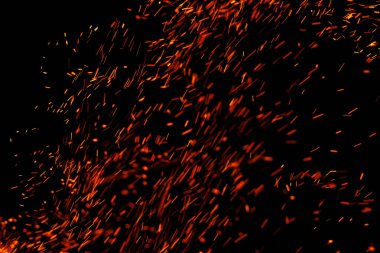 Siyah arkaplanda kıvılcımlar saçan bir ateş alevi