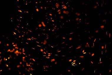 Siyah arkaplanda kıvılcımlar saçan bir ateş alevi