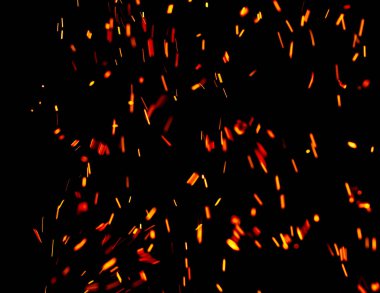 Siyah arkaplanda kıvılcımlar saçan bir ateş alevi