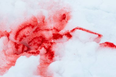Beyaz karda kırmızı boya lekeleri
