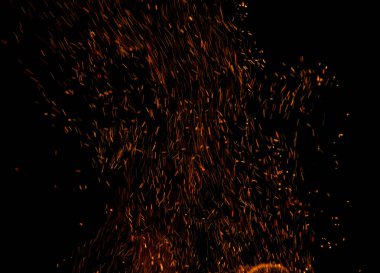 Siyah arkaplanda kıvılcımlar saçan bir ateş alevi