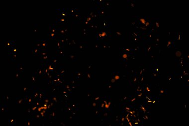 Siyah arkaplanda kıvılcımlar saçan bir ateş alevi