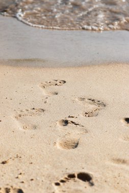 Deniz kenarındaki kumda ayak izleri.