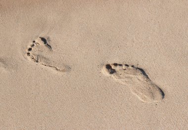Deniz kenarındaki kumda ayak izleri.
