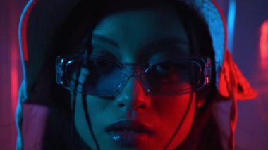 Güneş gözlüklü, mavi şapkalı, kırmızı ışıklı şık Asyalı kadın.