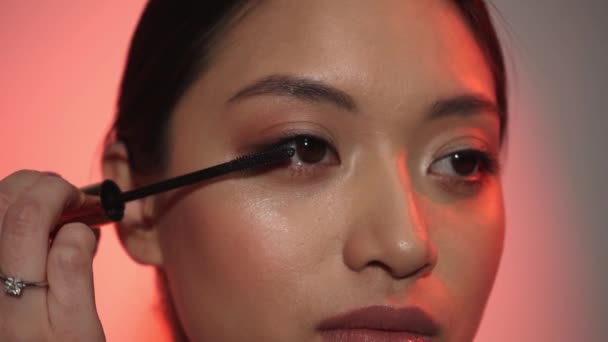Junge Asiatische Frau Anwendung Mascara Auf Rosa — Stockvideo