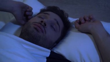 Uykulu adam sabahın erken saatlerinde yatakta esniyor ve esniyor.