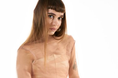 Kendine güvenen genç bir kadın, kendine has tarzını şık bir elbiseyle, parlak bir arkaplana karşı sergiliyor..