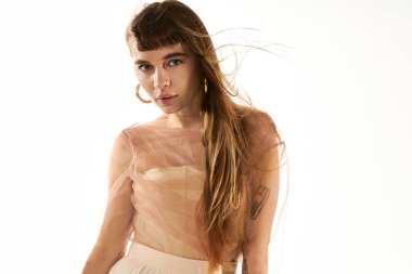 Güzel genç bir kadın moda anlayışını şık kıyafetleri ve büyüleyici varlığıyla sergiliyor.