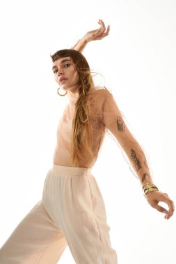 Uzun saçlı genç bir kadın dinamik bir şekilde şık bir şekilde poz veriyor..