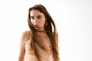 Şık giyinmiş, kendine güvenen, dalgalı saçlı, enerjik bir arkaplanı olan bir kadın..