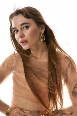 Hafif giysili kendinden emin genç bir kadın saçlarını dalgalandırarak huzurlu bir anın tadını çıkarıyor..