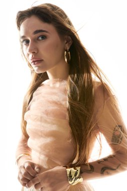 Genç, güzel bir kadın şık poz veriyor, moda anlayışını ve aksesuarlarını ön plana çıkarıyor..