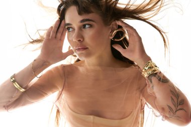 Dalgalı saçlı genç bir kadın zarif poz verirken stilini ve zarafetini sergiliyor..