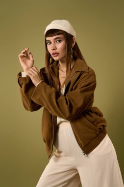 Kendine güvenen genç bir kadın şık bir ceket ve şık aksesuarlarla gösteriş yapar..