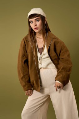 Genç, güzel bir kadın, kendine güvenen bir şekilde, modaya uygun bir şekilde poz verir, zahmetsiz bir cazibe yayar..