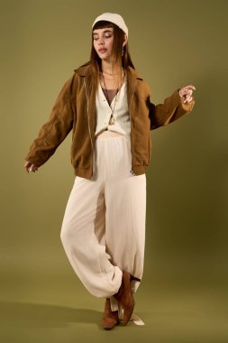 Güzel genç bir kadın rahat bir duruşu olan şık bir kıyafet sergiliyor..