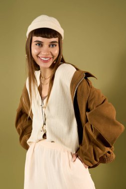 Genç ve güzel bir kadın kendine güvenerek poz veriyor, modaya uygun kıyafetlerini ve neşeli ruhunu sergiliyor..