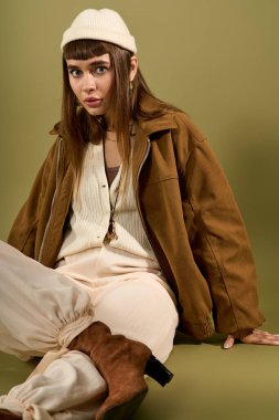 Genç ve güzel bir kadın zarif bir şekilde oturur, şık elbisesini ve kendine güvenini gösterir..