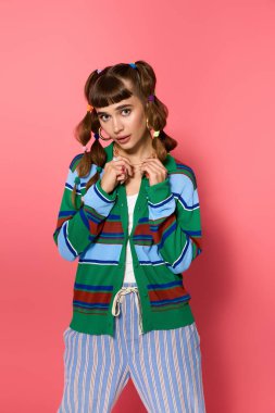 Zarif genç kadın cazibesiyle poz veriyor, renkli kıyafetlerini ve hayat dolu ifadesini sergiliyor..